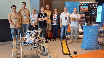 Pracownicy Politechniki Częstochowskiej na stoisku Uczelni podczas kongresu stalowego. Łazik PCz i PCz Rover Team.