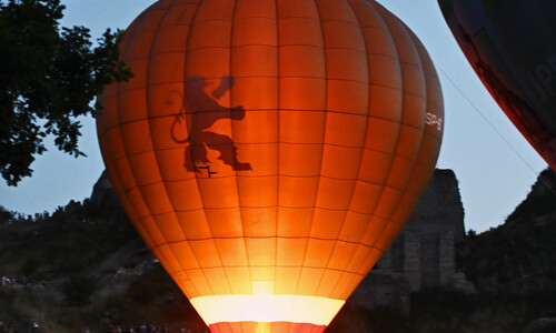 Balon z widocznym ogniem podgrzewającym powietrze w jego wnętrzu i jednocześnie rozświetlającym go