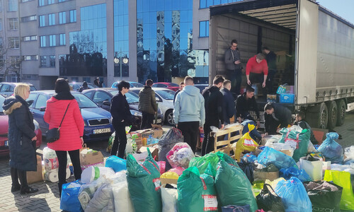 Paczki czekające na załadowanie na TIRa który pojedzie z pomocą na Ukrainę. Ludzie którzy uczestniczą w całej akcji pomocy pakujący auto