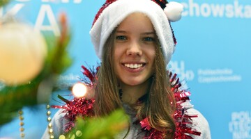 Studentka w przebraniu świątecznym przy choince