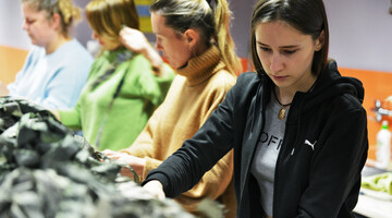 Dziewczyny zaplatają siatkę maskującą dla Ukrainy.