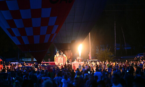 widok nocny na plac pod zamkiem w Olsztynie i podświetlone balony