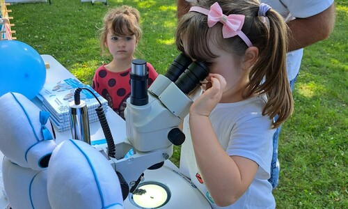 dziewczynka przy mikroskopie, stoisko Politechniki Częstochowskiej,