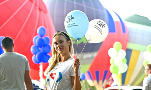 Studentka pozująca z balonami reklamowymi Politechniki Częstochowskiej a w tle Balony latające