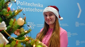 Studentka w przebraniu świątecznym przy choince