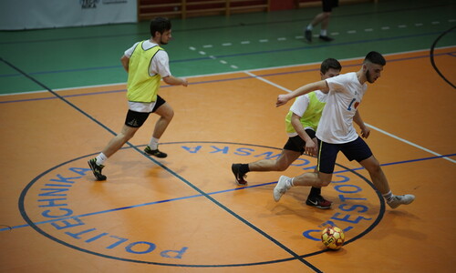 Studenci grający w piłkę nożną w trakcie meczu.
